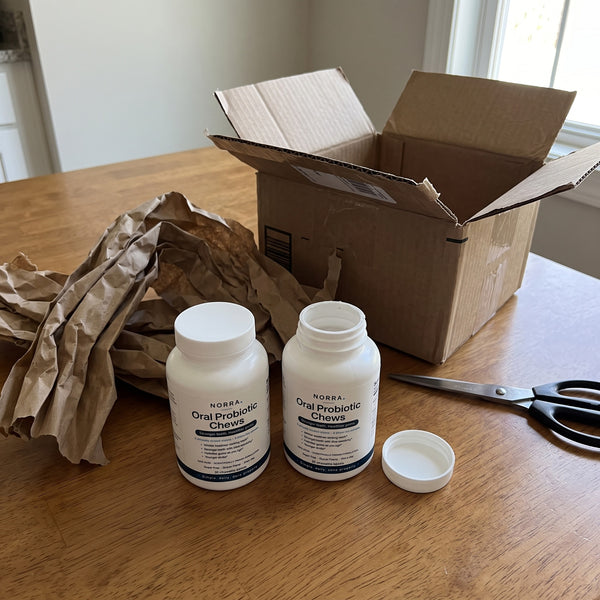 Two bottles of Norra beside a just-opened shipping box